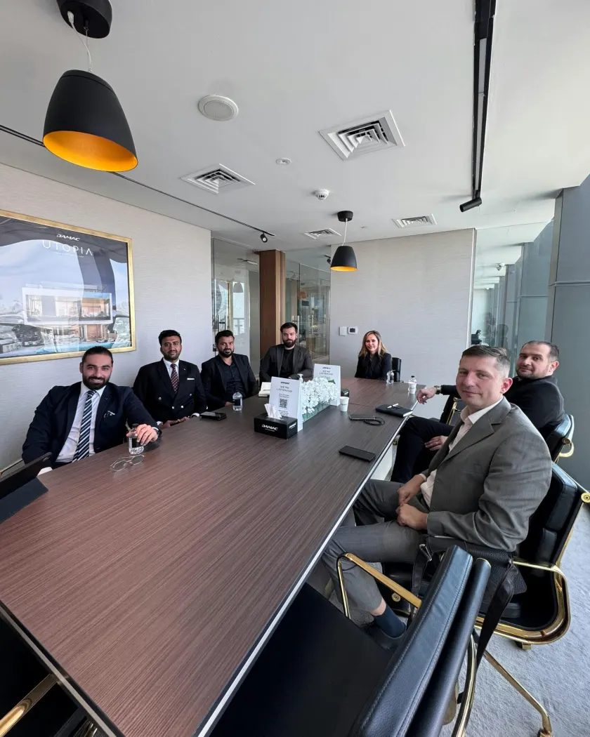 Executives seated around a long boardroom table during a review meeting.