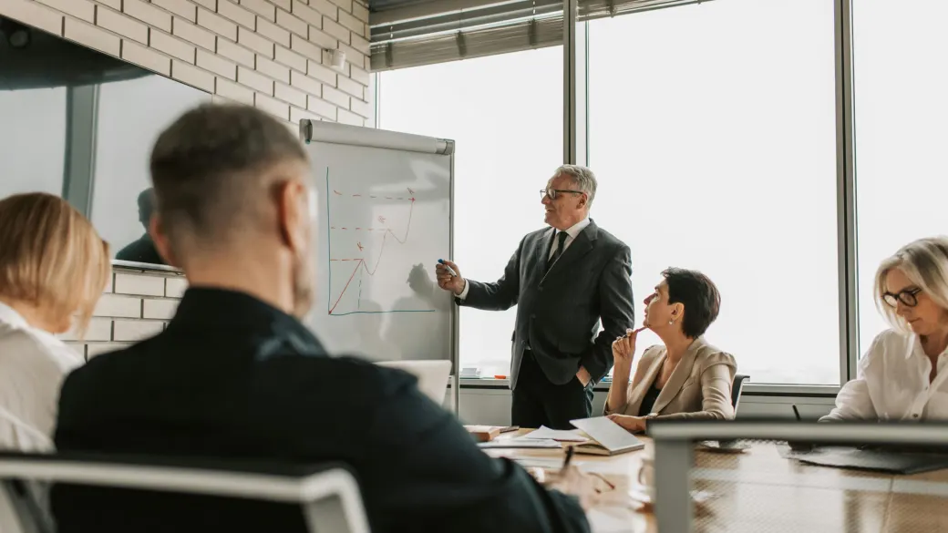 A facilitator at a flipchart takes a leadership team through its thinking.