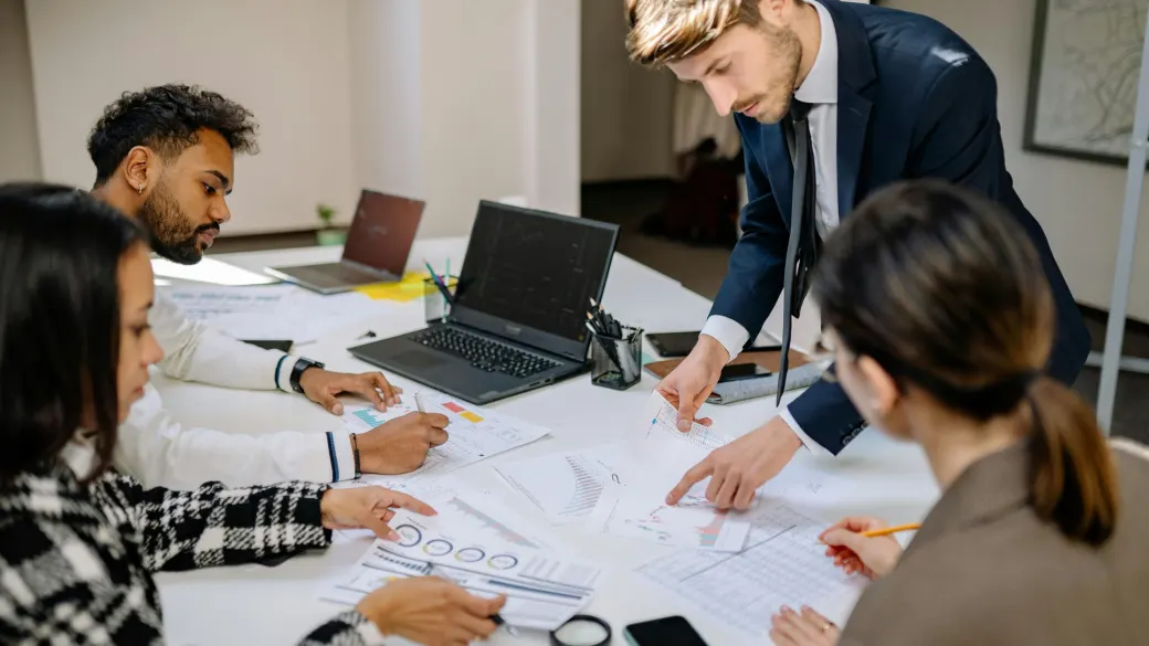 A team works through printed charts together at a shared table.