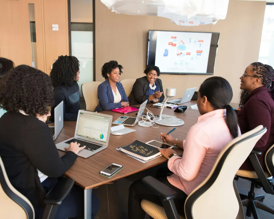 A leadership team meets around a table, with the quarter’s figures on the screen behind them.