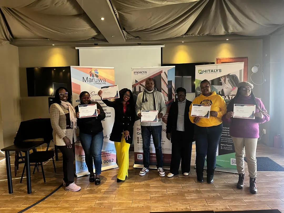 Participants stand together holding their certificates.