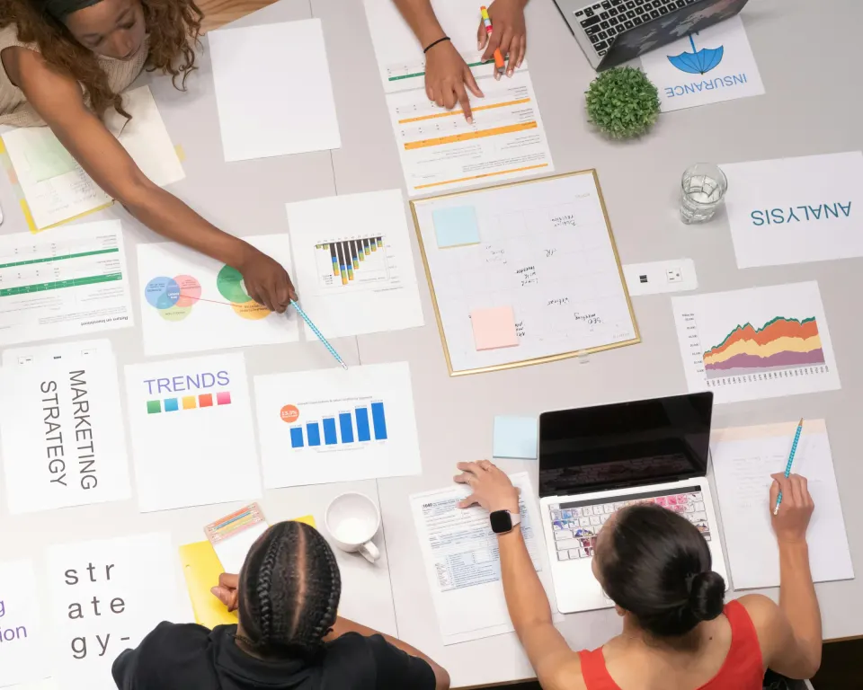 Seen from above, a team lays out and works through its strategy papers on a shared table.